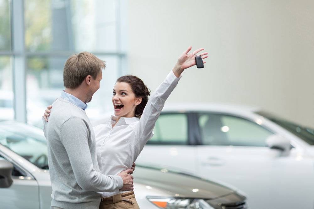 Mladý pár sa raduje z kúpy nového auta
